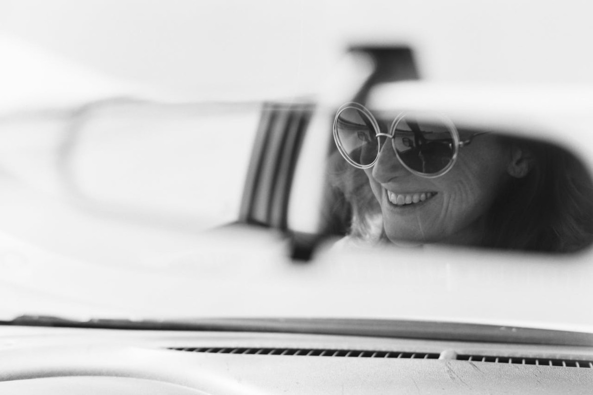 Persona che sorride e che va al lavoro in auto