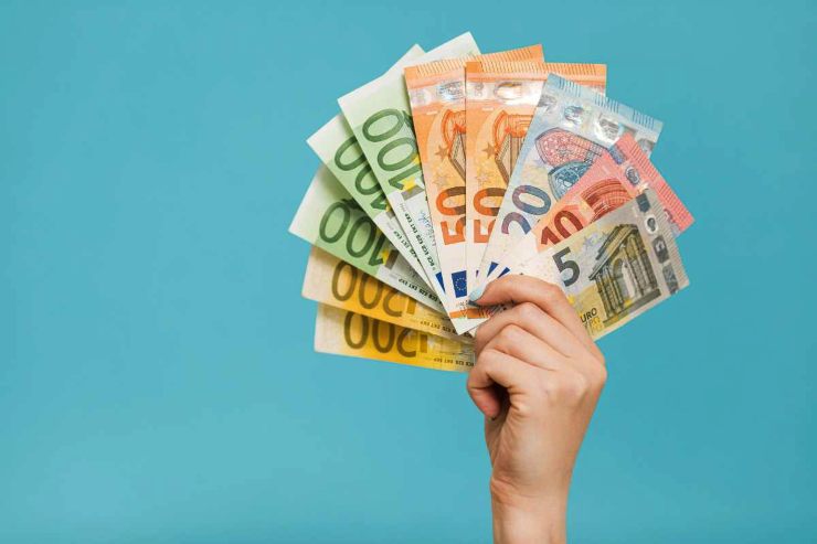 Mano regge un ventaglio di banconote