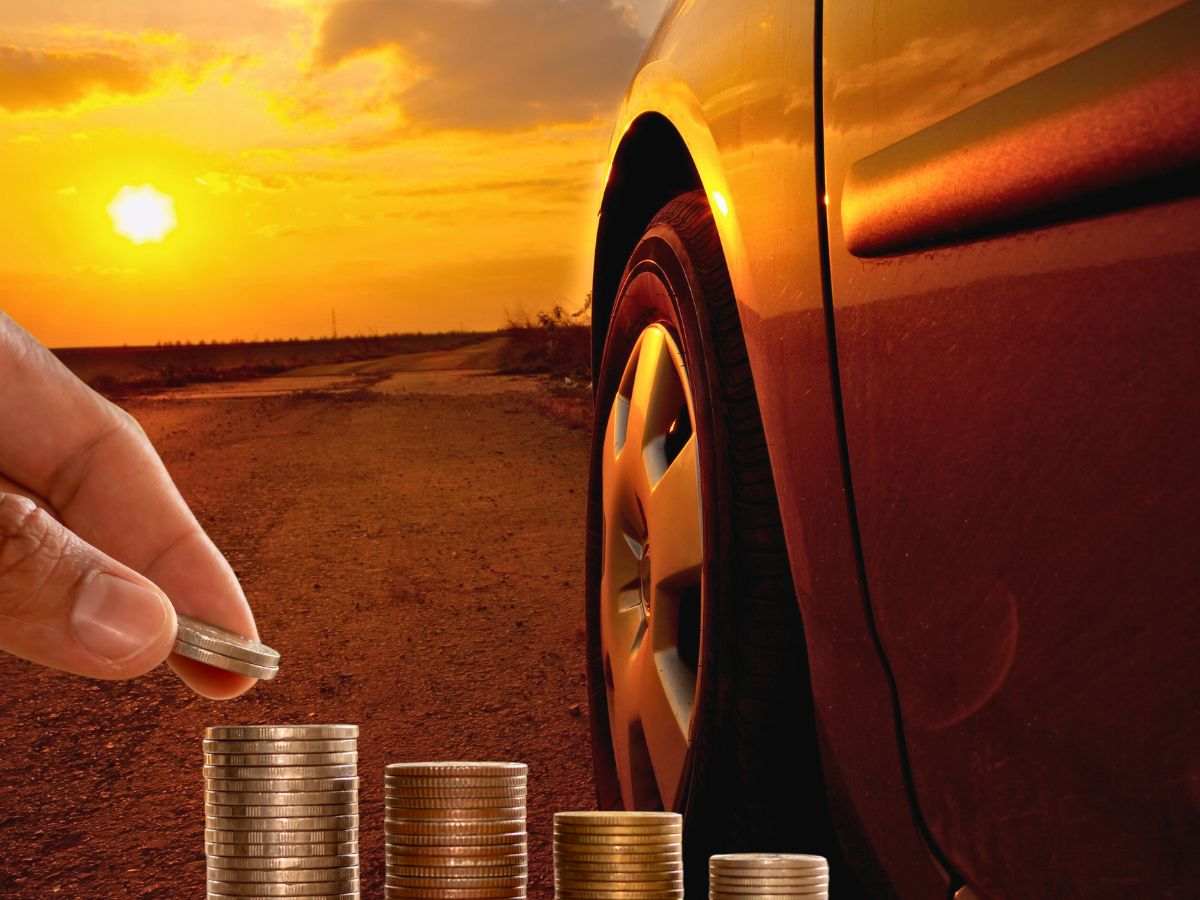 sfondo auto al tramonto con mano che impila monete euro