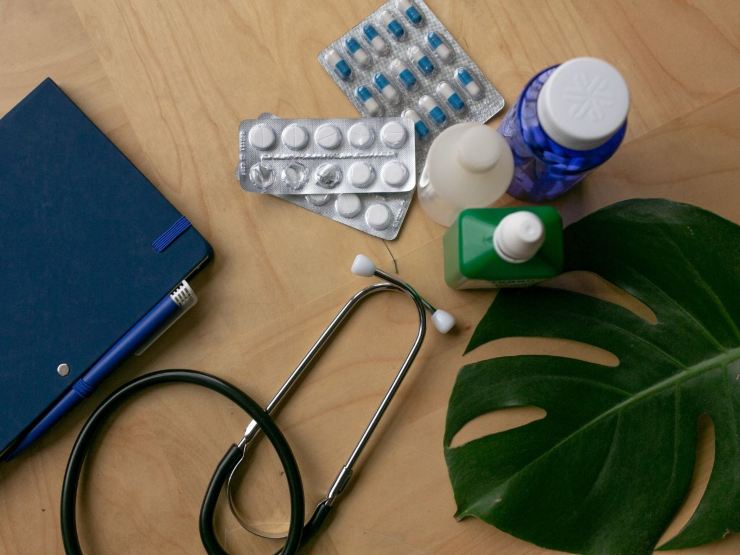 scrivania con foglia pianta, medicinali, stetofonendoscopio e cartella