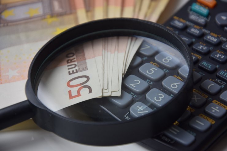 lente di ingrandimento su banconote da 50 euro e calcolatrice
