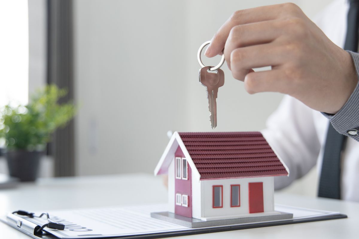 Miniatura casa e chiavi tenute in mano