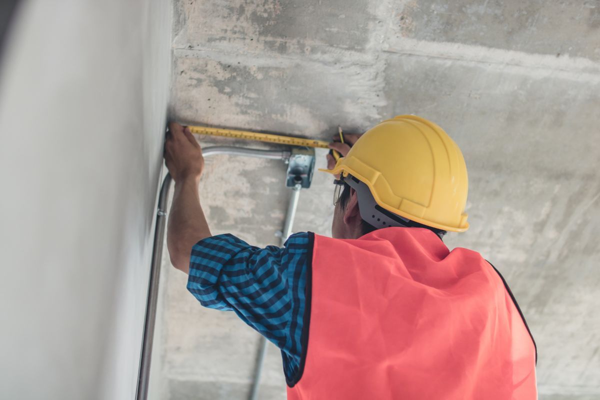 Operaio che prende le misure di un soffitto