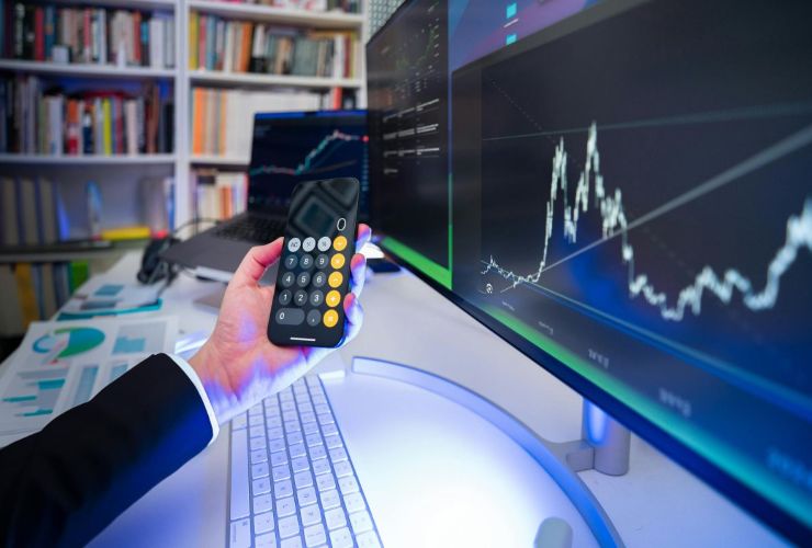Grafico mercati e persona che fa i calcoli