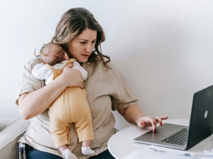 mamma al pc con bambino in braccio
