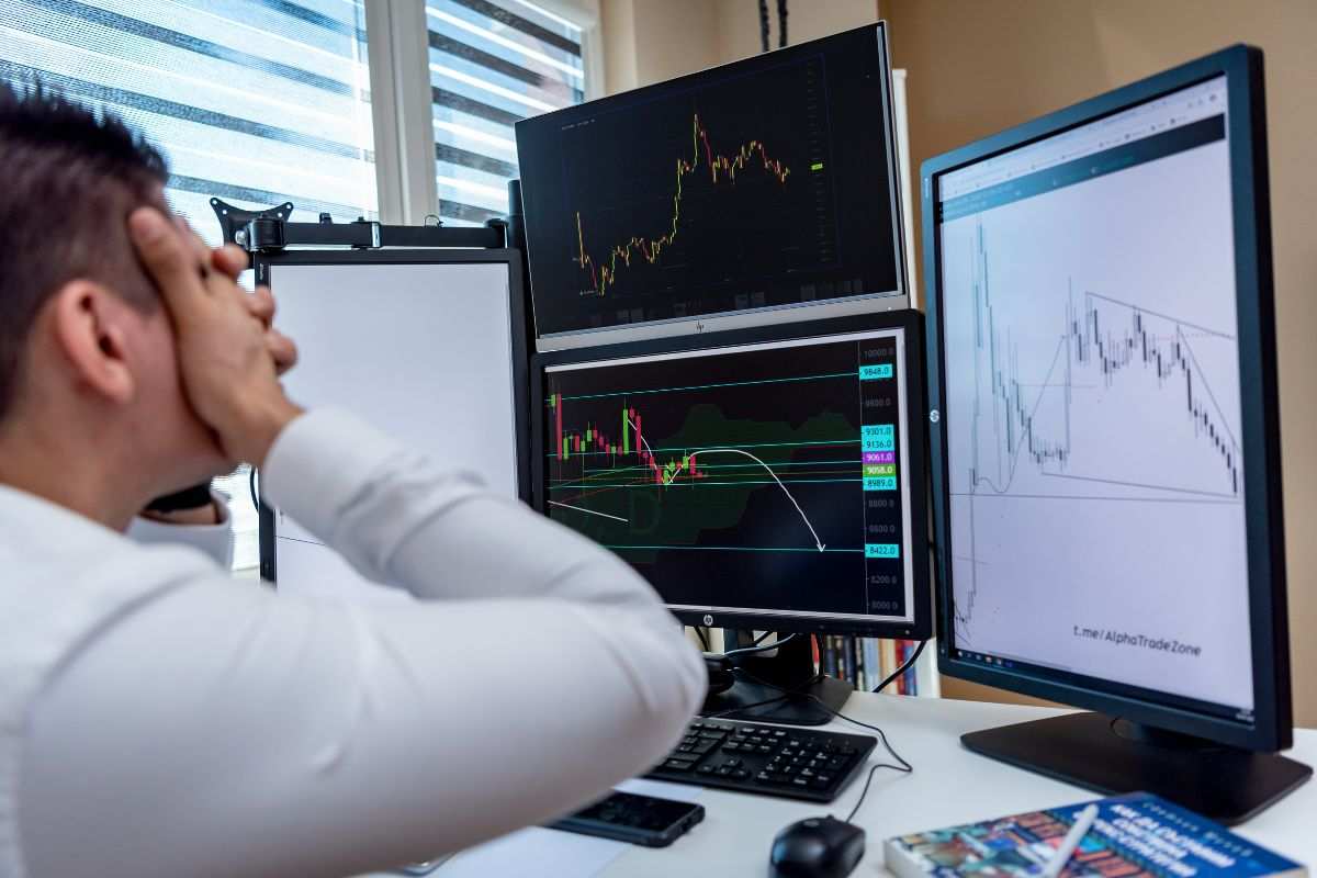 Persona spaventata mentre osserva un ribasso dei mercati