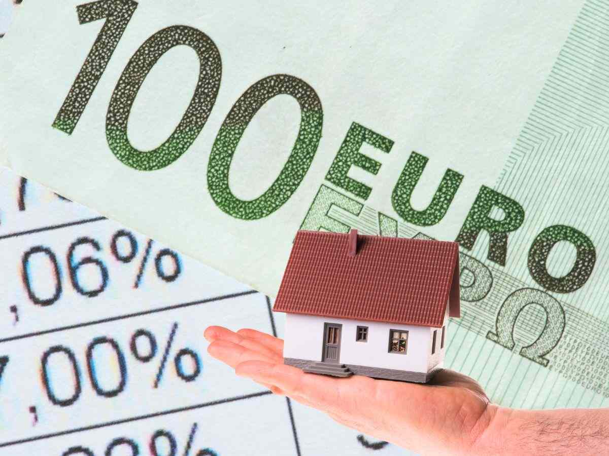sfondo documento con cifre percentuali e banconota 100 euro e casetta in miniatura in mano
