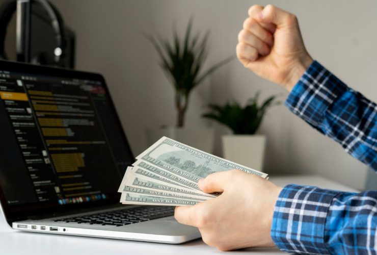 Persona che mantiene soldi in mano mentre guarda i mercati