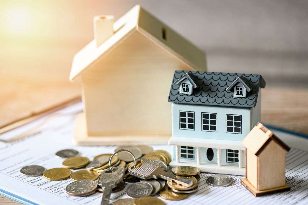Casa in miniatura, chiavi e monete