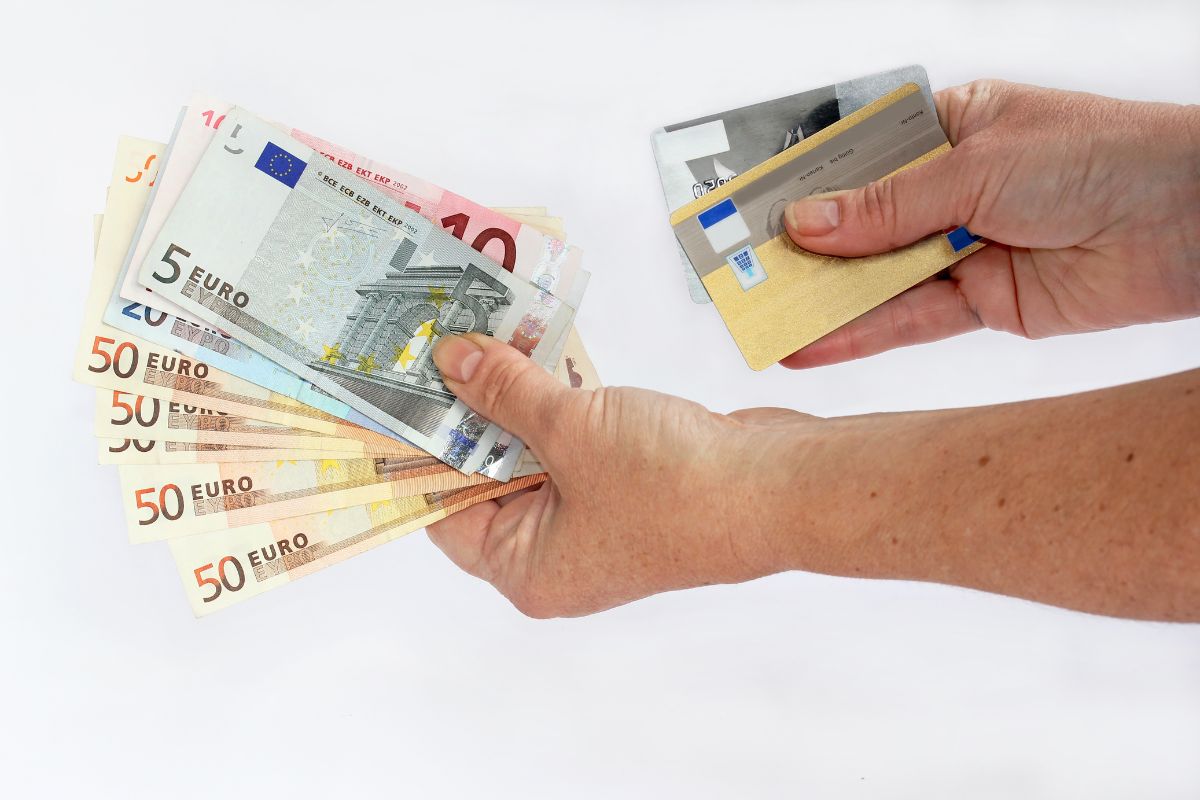 Persona che ha in mano contanti e carte