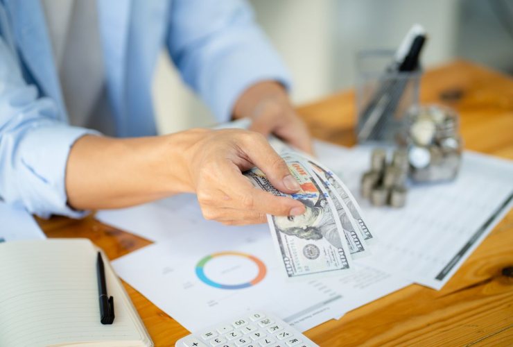 Persona che conta dollari e analizza dati