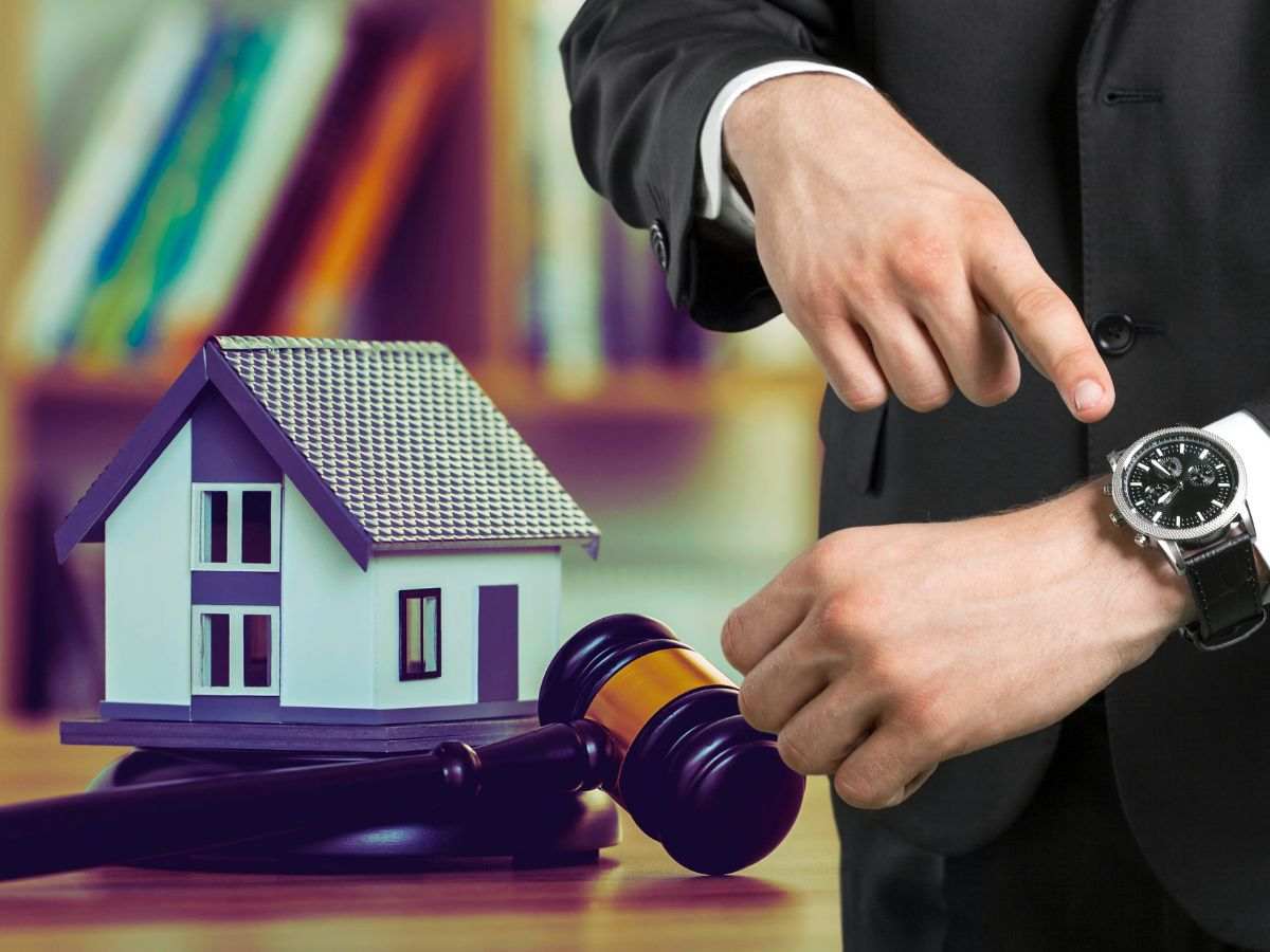 sfondo casa i miniatura e martelletto del giudice e uomo che indica orologio