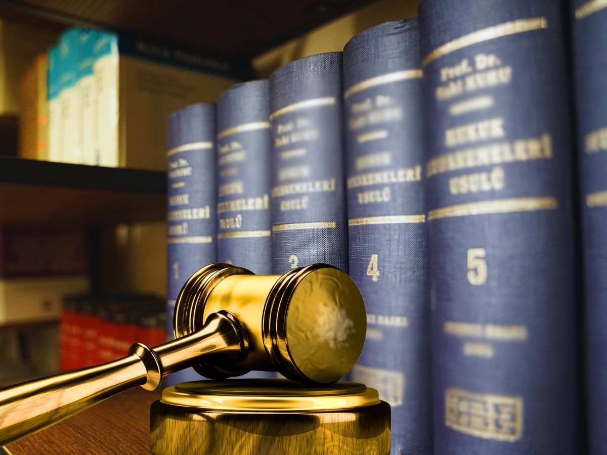 sfondo manuali di diritto e martelletto del giudice dorato