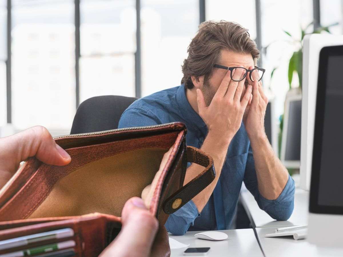 sfondo uomo in crisi alla scrivania e portafoglio vuoto in mano