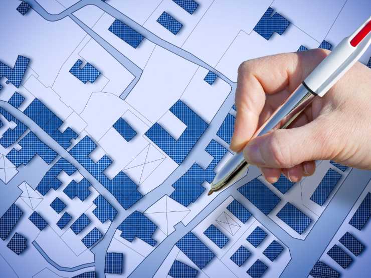 carta planimetria e mano con penna che fa segno