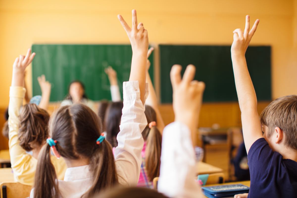 classe scuola bambini con mano alzata