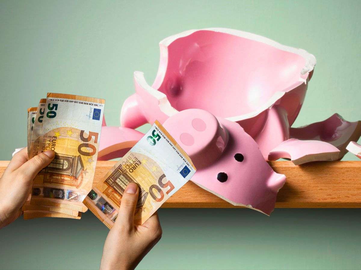 sfondo maialino rotto e banconote 50 euro in mano