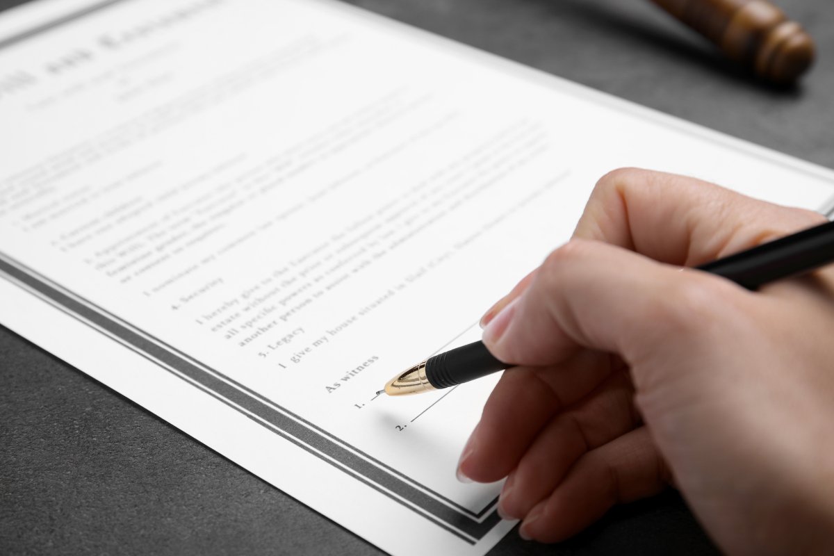penna che sta per firmare documento