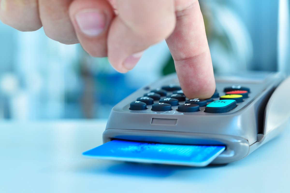 dito che preme pulsante pos con carta inserita