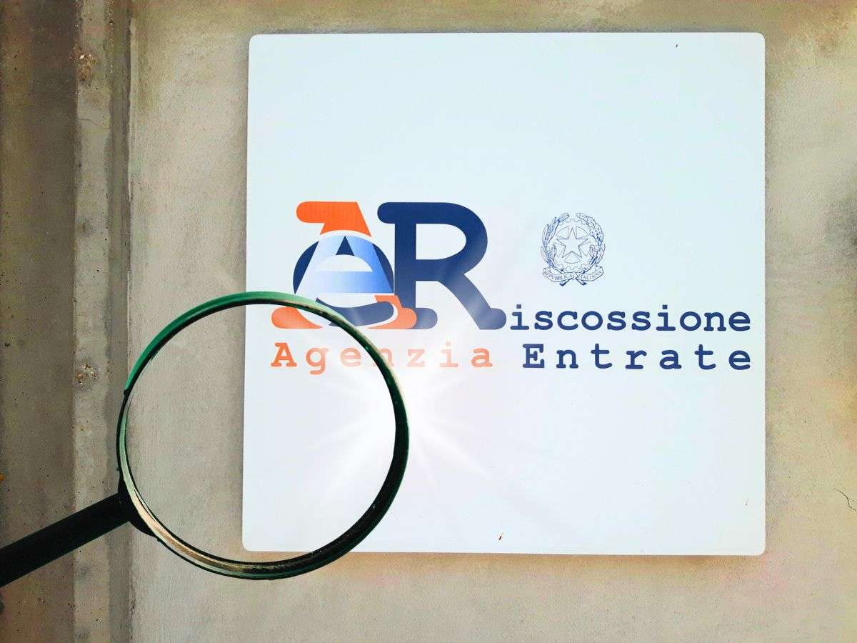 sfondo cartello Agenzia delle Entrate e lente di ingrandimento
