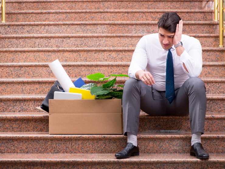 lavoratore licenziato seduto su scalinata
