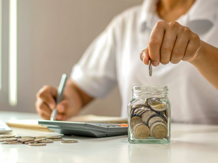 uomo fa calcoli con monete euro e le mette nel barattolo