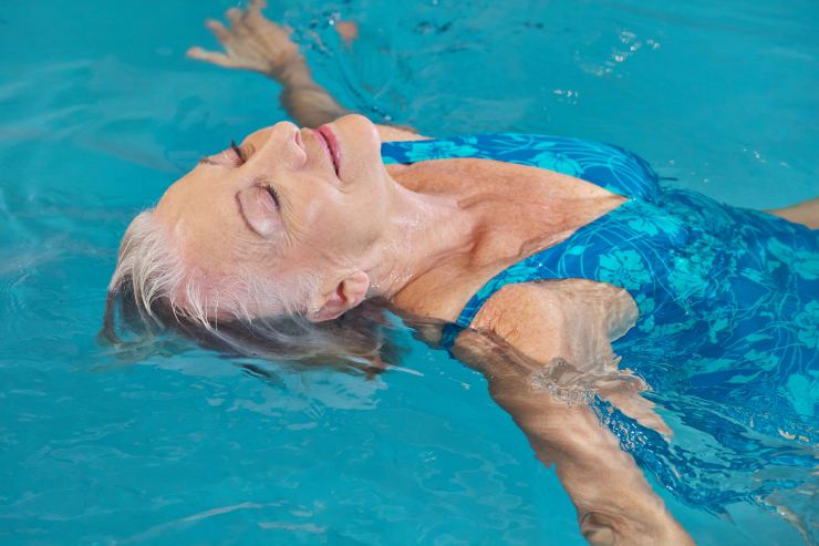 donna rilassata in acqua a dorso