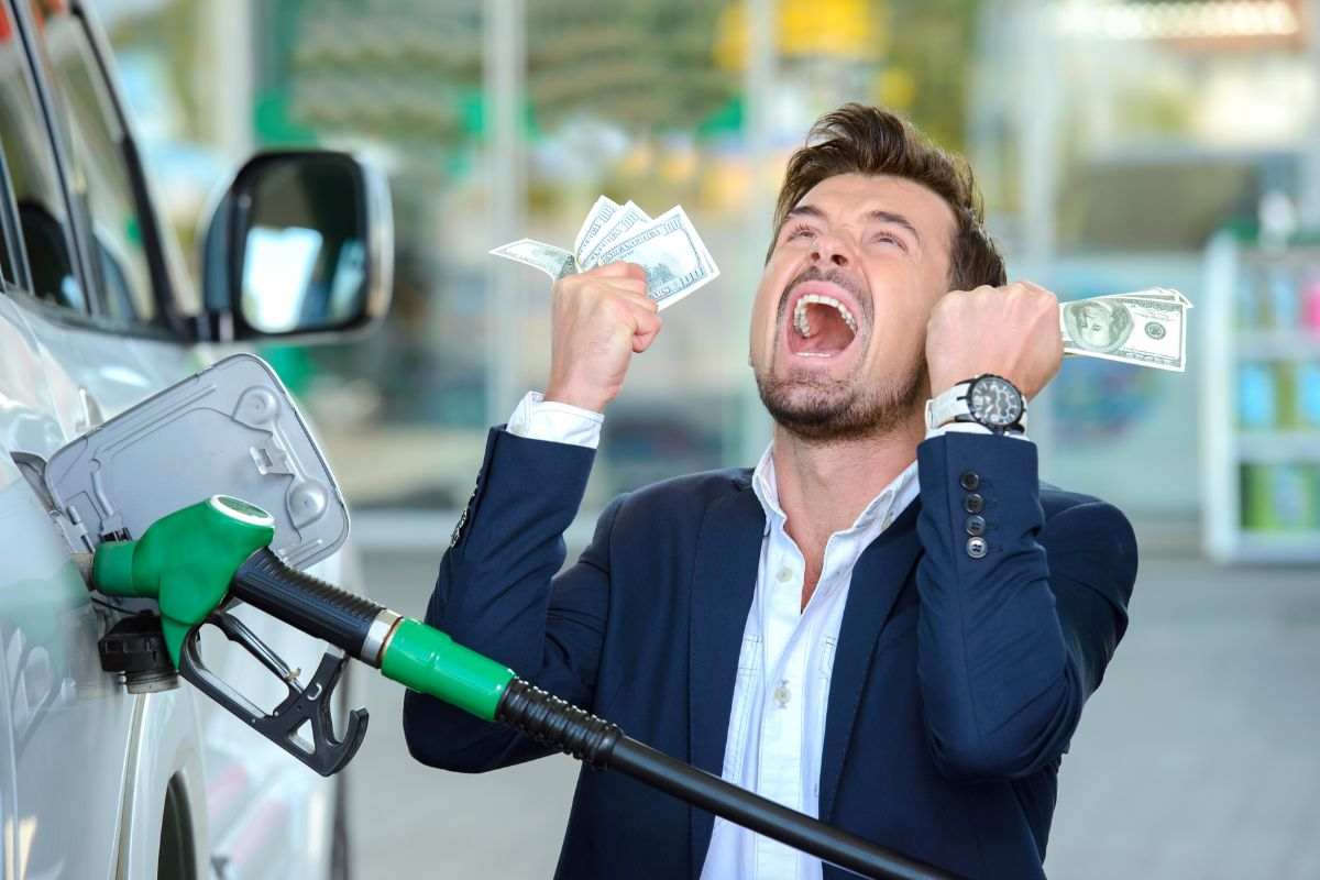 Persona che urla mentre fa benzina per i costi elevati