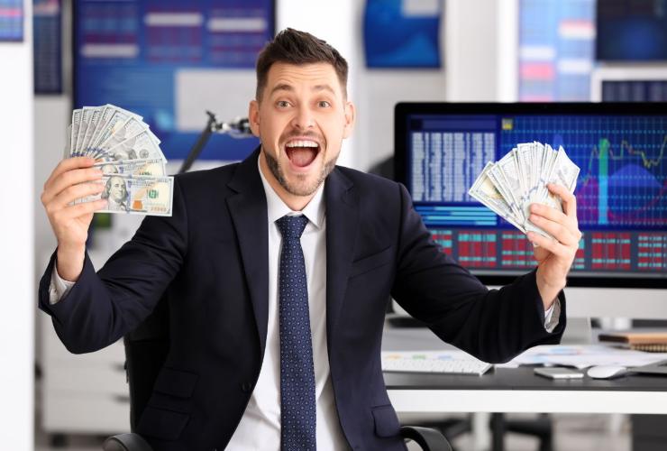 Analista euforico con in mano dei dollari