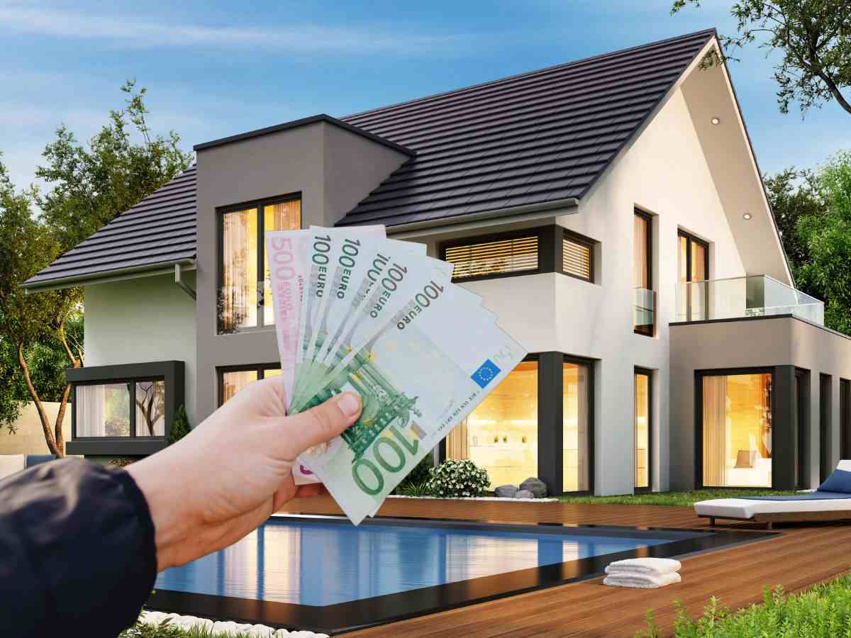 sfondo casa e mano con banconote euro