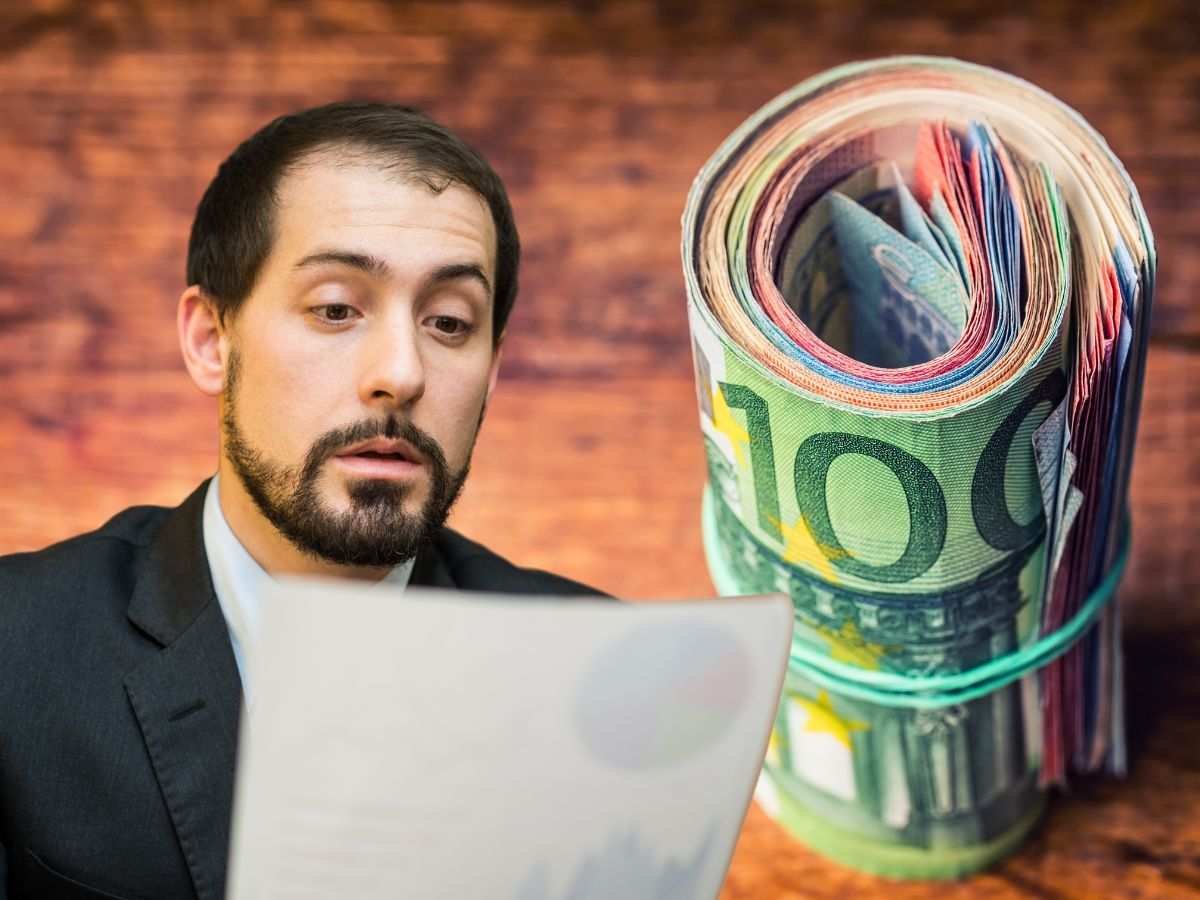 sfondo banconote euro arrotolate e uomo che legge documento