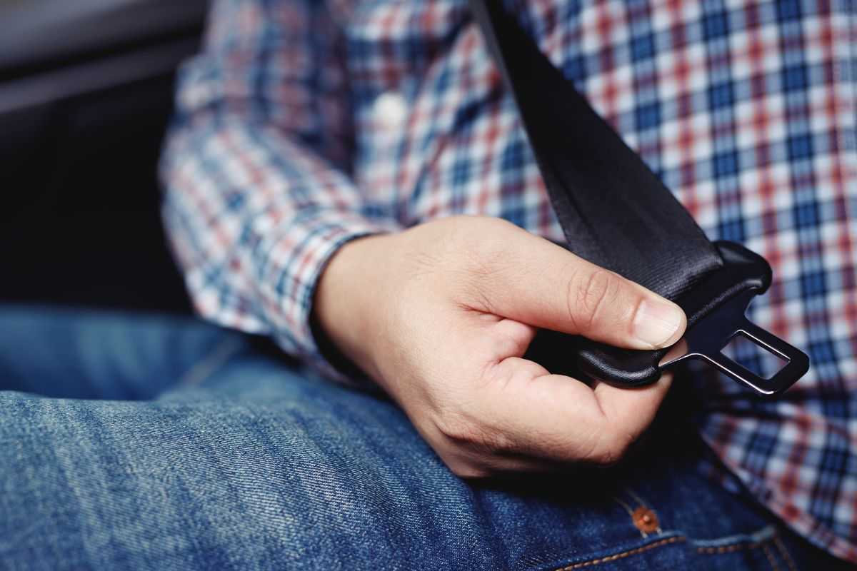 Persona che mette la cintura