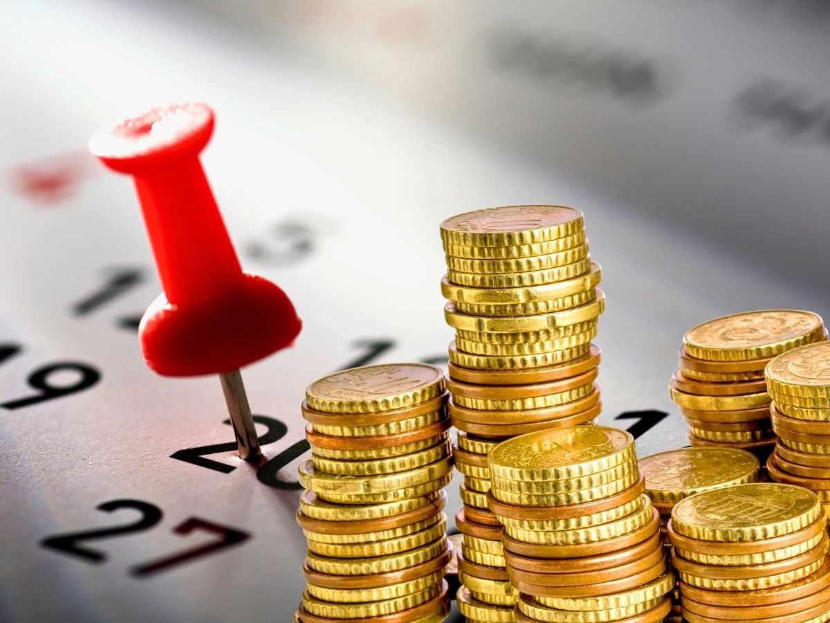 sfondo calendario con puntina e monete euro ammucchiate