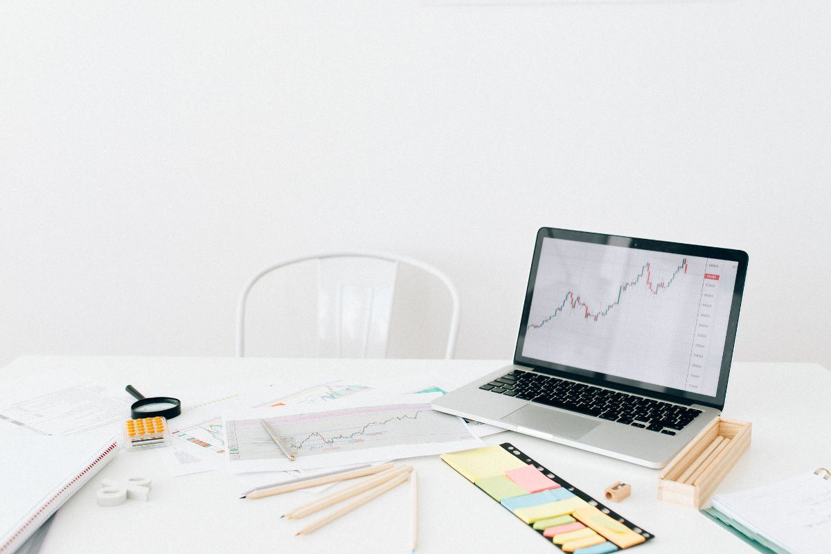 Monitor con grafico di borsa, matite e garfici
