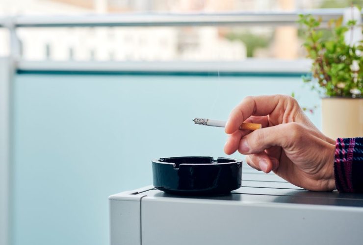 Persona che fuma e usa il portacenere