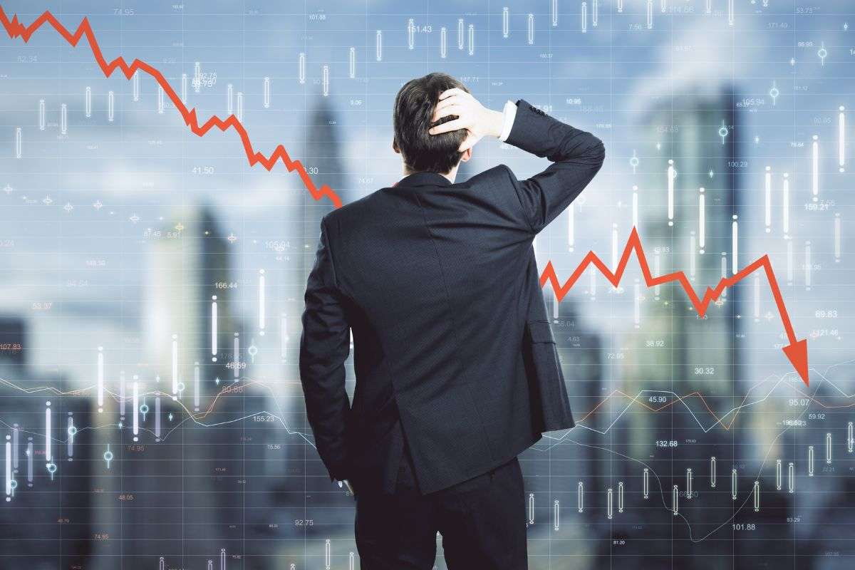 Persona preoccupoata che guarda un grafico dei mercati in discesa