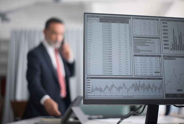 Persona al telefono mentre analizza grafici e dati