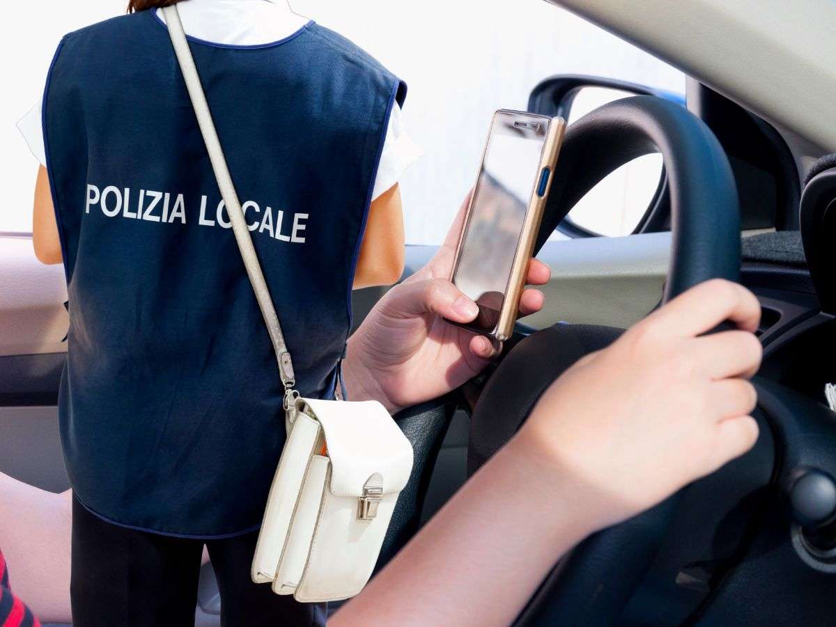 sfondo persona alla guida con cellulare e vigile urbano di spalle