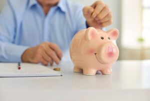 Persona che mette una moneta nel salvadanaio