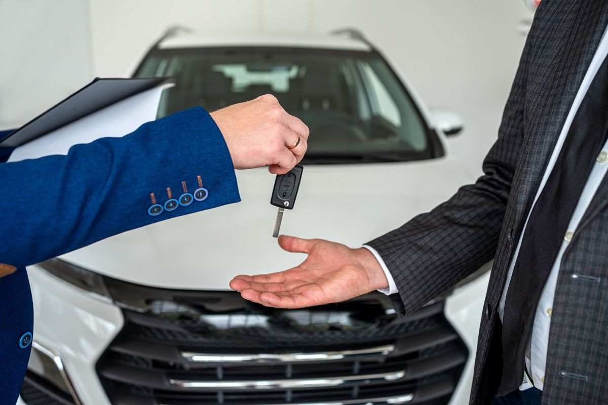 Persone che si scambiano chiave dopo vendita auto