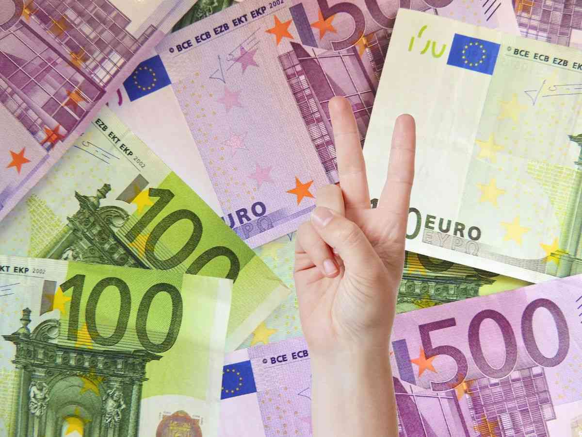 sfondo banconote euro e mano che fa due
