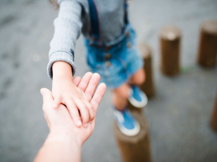 bambino mano nella mano con adulto