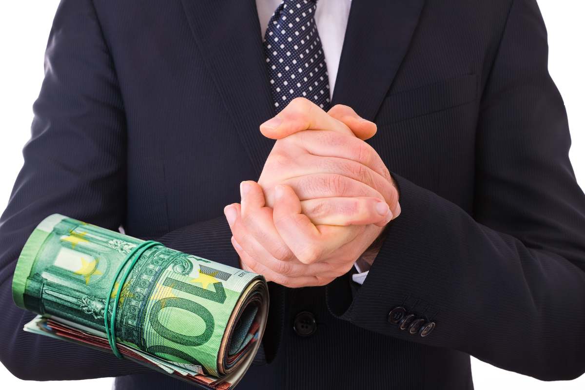 uomo si strofina le mani di fronte a banconote