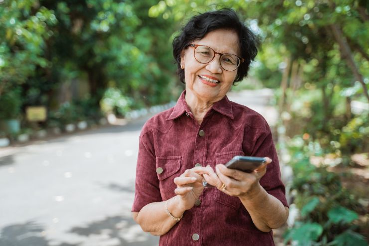 donna sorridente con cellulare in mano