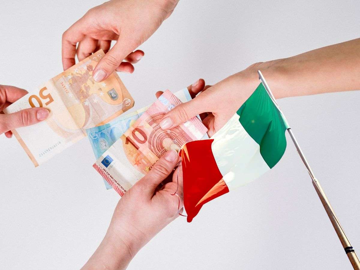 sfondo banconote euro tra le mani e bandiera italiana