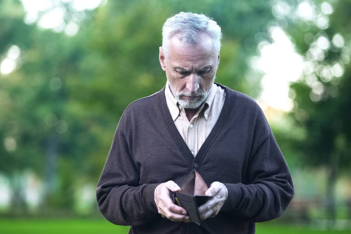 pensionato con portafogli vuoto in mano