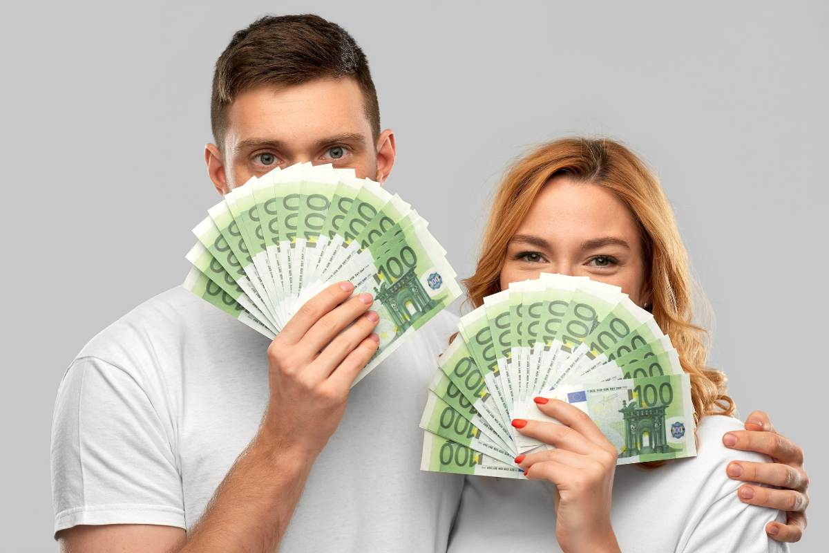 ragazzo e ragazza pieni di banconote da 100 euro a ventaglio