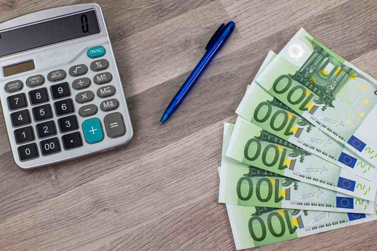 Banconote, calcolatrice e penna