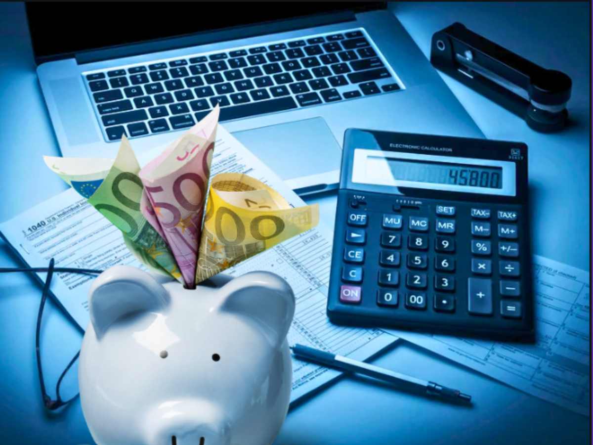 sfondo scrivania con pc e calcolatrice e salvadanaio maialino con banconote euro
