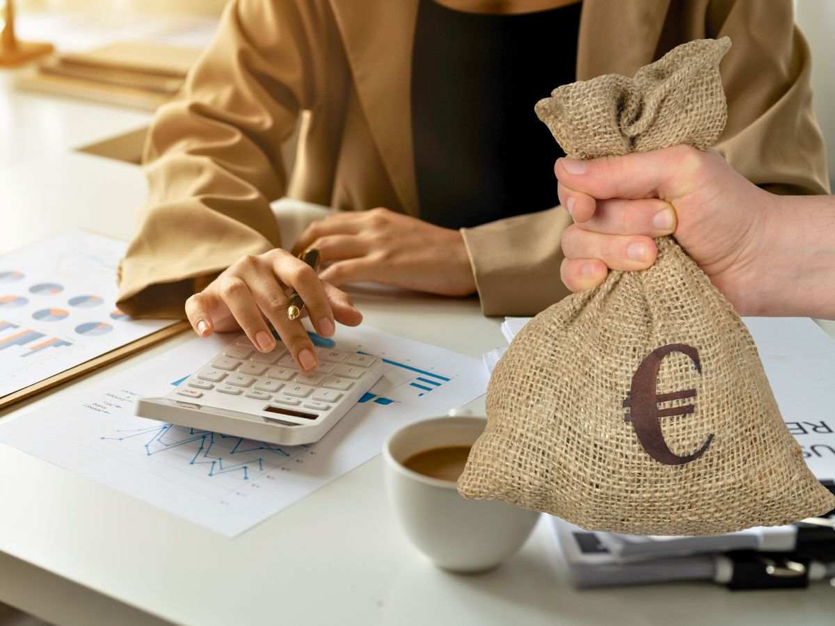 sfondo donna fa calcoli alla calcolatrice e mano con sacco con simbolo euro